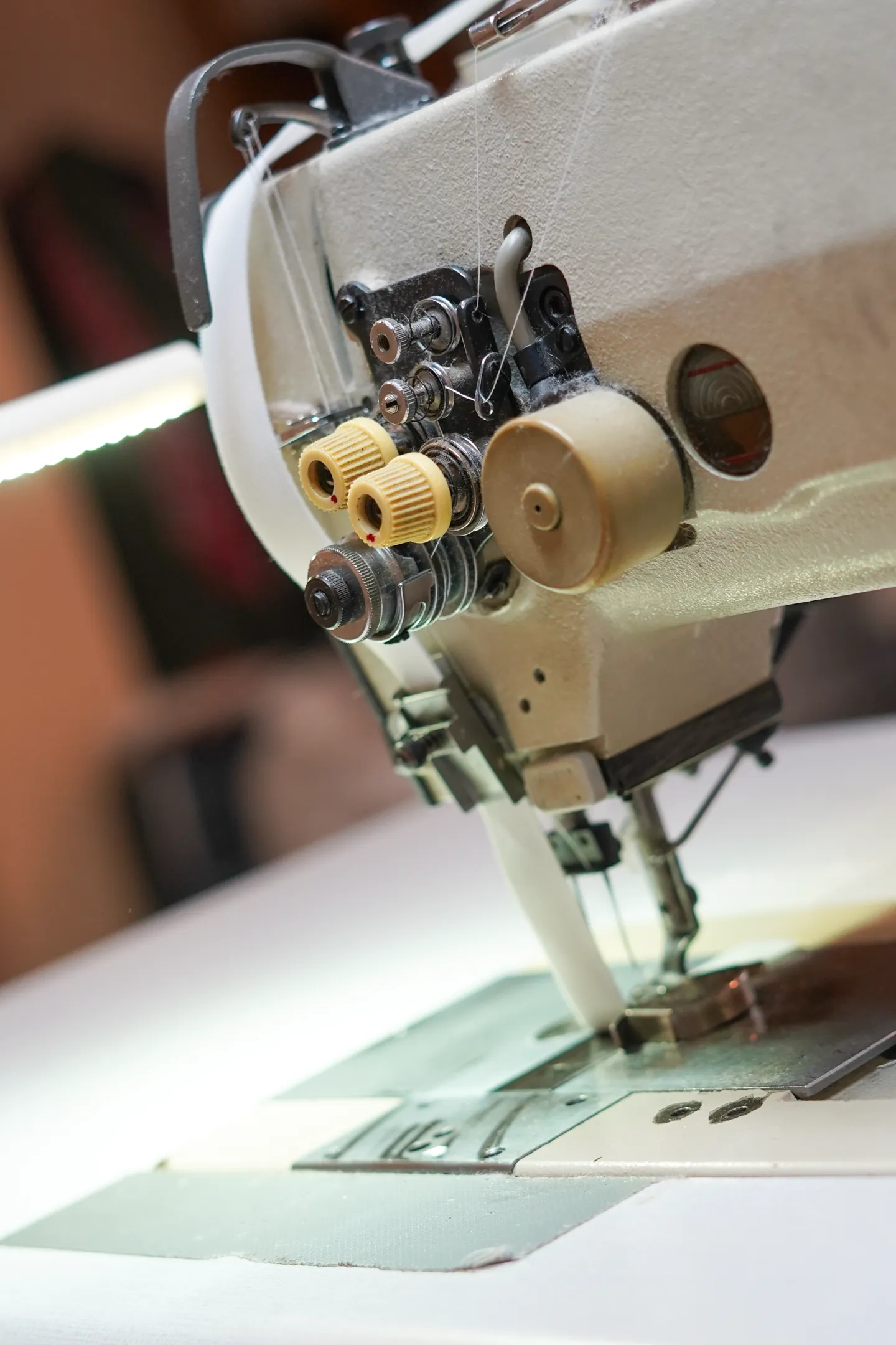 Detalle de máquina de coser industrial trabajando en confección de cortinas a medida en Barcelona